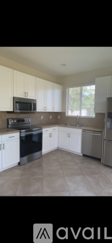 A kitchen with white cabinets and a black stove top oven.