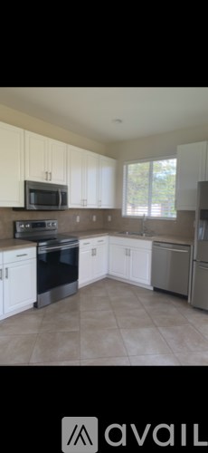 A kitchen with white cabinets and a black stove top oven.