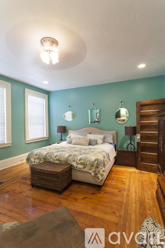 A bedroom with a bed, a dresser, and a mirror.