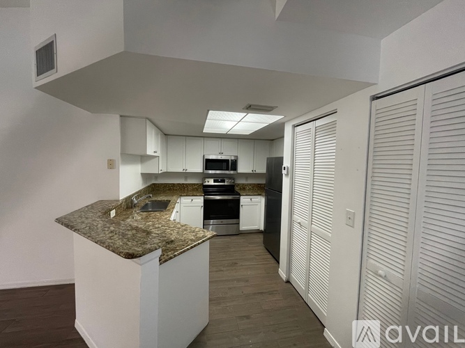 A kitchen with granite countertops and white cabinets.