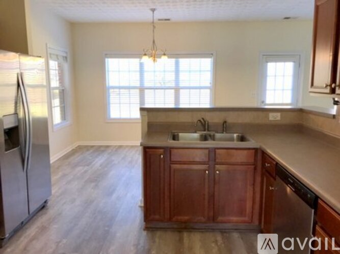 A kitchen with wooden cabinets and a refrigerator.