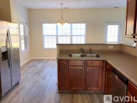 A kitchen with wooden cabinets and a refrigerator.