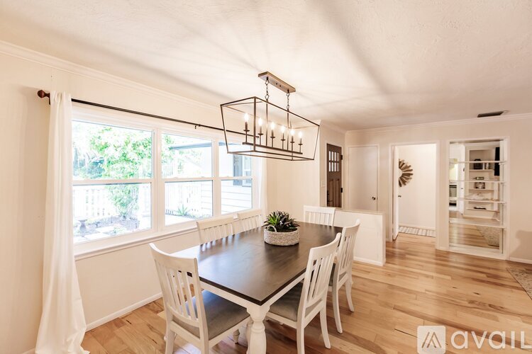 A dining room with a table and chairs and a chandelier.