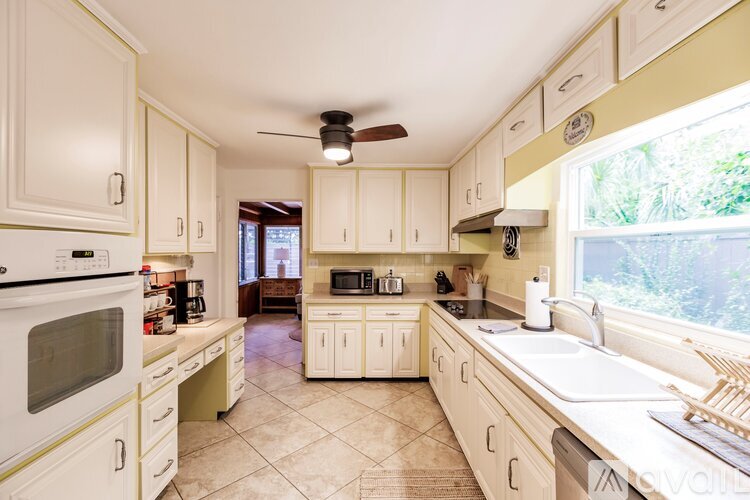 A kitchen with white cabinets and appliances.