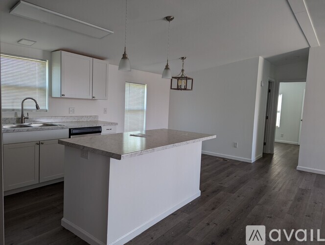 A kitchen with white cabinets and a marble countertop.