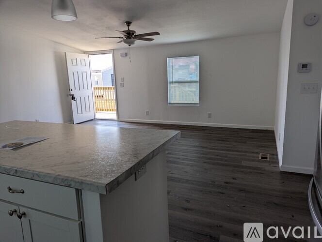 A kitchen with a marble countertop and a ceiling fan.