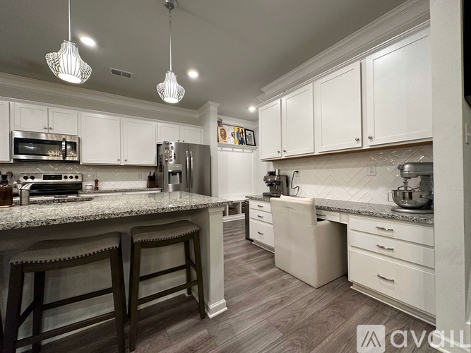 A kitchen with white cabinets and a granite countertop.