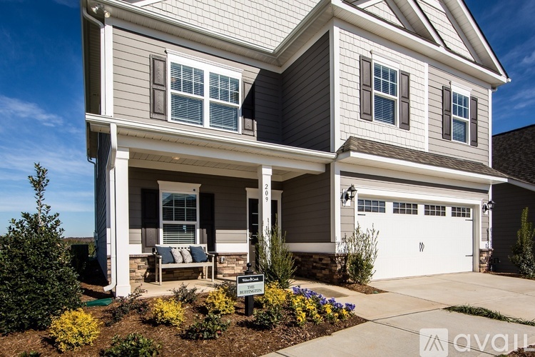 A house with a grey and white exterior and a garage.