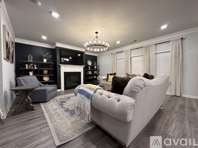 A modern living room with a grey sofa and a fireplace.