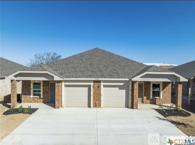 A house with a brick facade and a grey roof is shown.