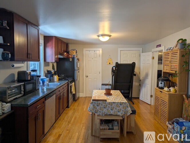 A kitchen with wooden cabinets and a black refrigerator.