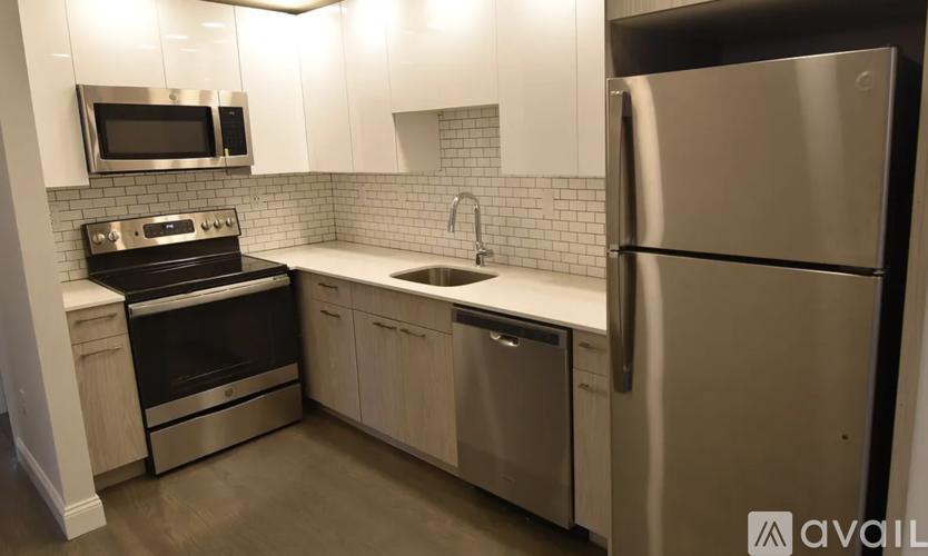 A modern kitchen with stainless steel appliances and white cabinets.