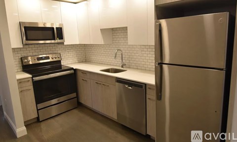 A modern kitchen with stainless steel appliances and white cabinets.