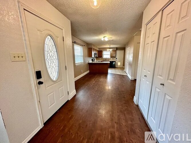 A long hallway with white doors and a wooden floor.