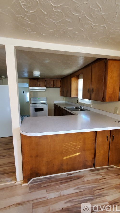 A kitchen with wooden cabinets and a white island.