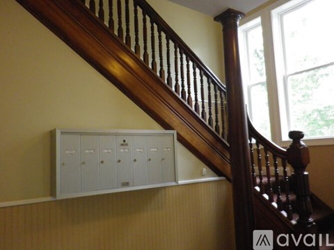 A staircase with a wooden banister and a wall-mounted mailbox.