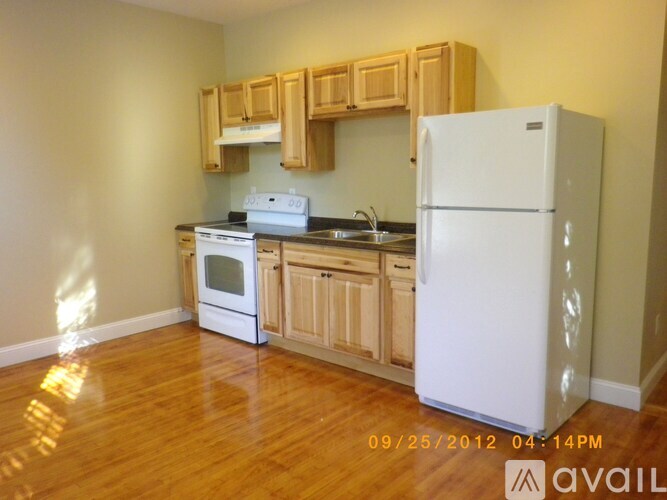 A kitchen with wooden cabinets and a white refrigerator.