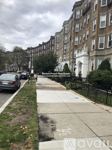 A street view of a residential area with apartment buildings on the side.