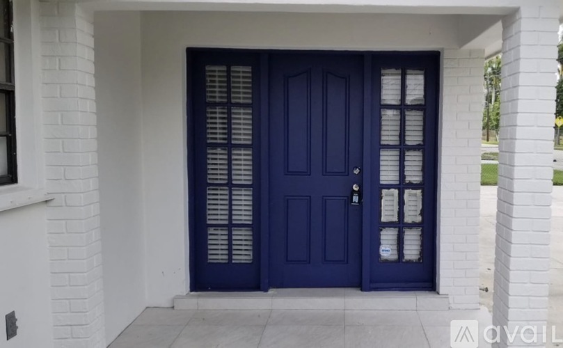 A blue door with a glass panel and a white wall.