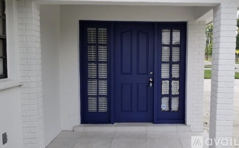 A blue door with a glass panel and a white wall.
