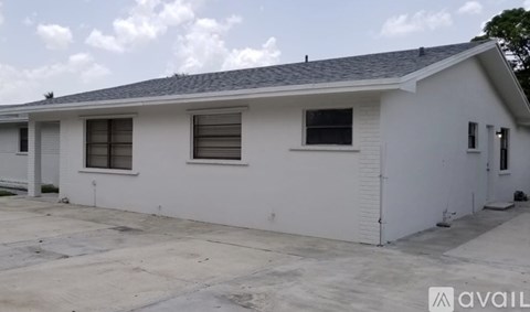 A white house with a grey roof and a sign that says "available".