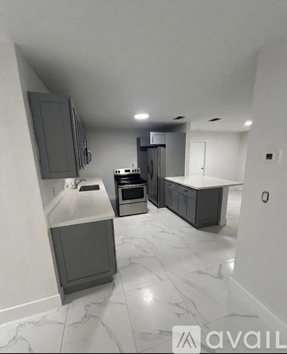 A kitchen with marble flooring and grey cabinets.