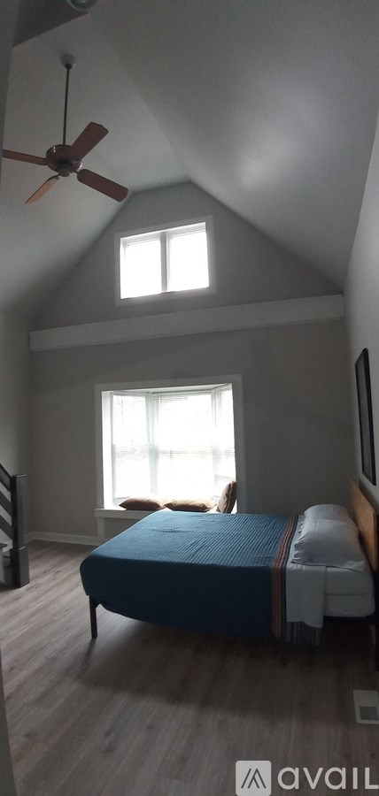A bedroom with a bed and a ceiling fan.