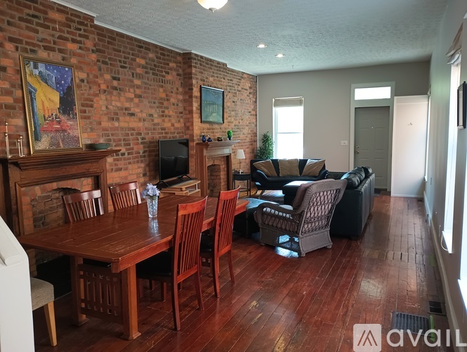 A living room with a brick wall and wooden floors.