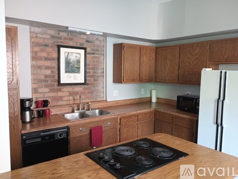 A kitchen with a stove top oven and a fridge.