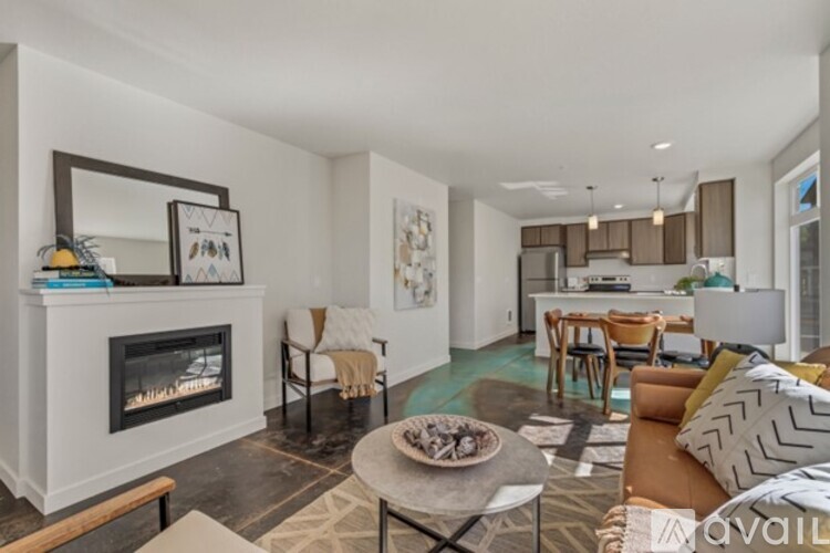 A living room with a fireplace and a dining area in the background.