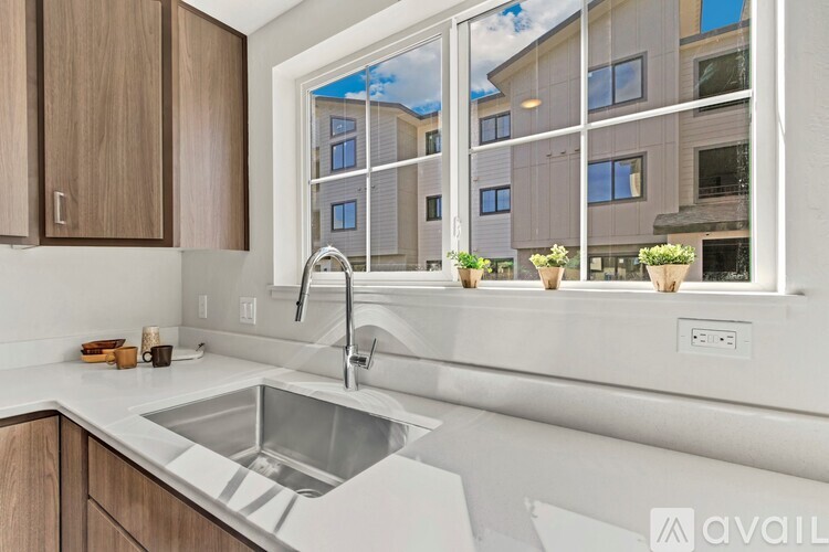 A modern kitchen with a large window overlooking a building.
