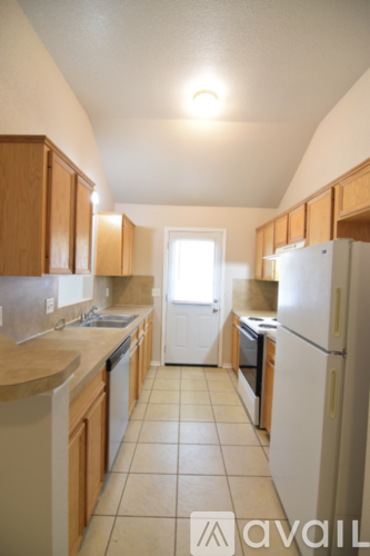 A kitchen with wooden cabinets and a white refrigerator.