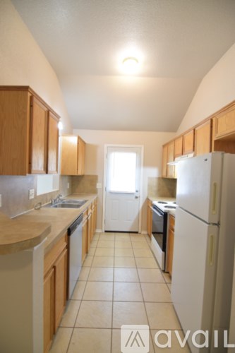 A kitchen with wooden cabinets and a white refrigerator.