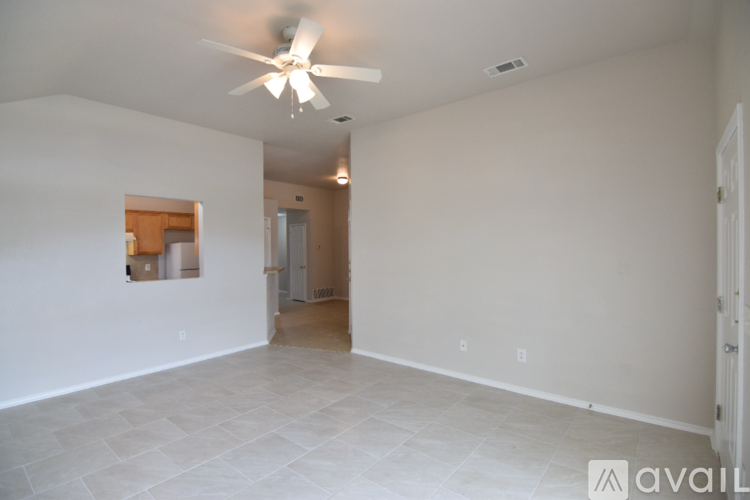 A spacious room with a ceiling fan and tiled flooring.