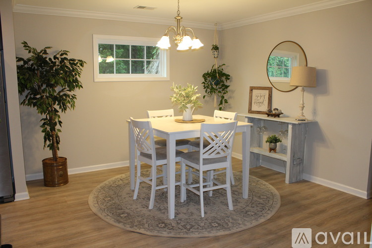 A dining room with a white table and chairs.