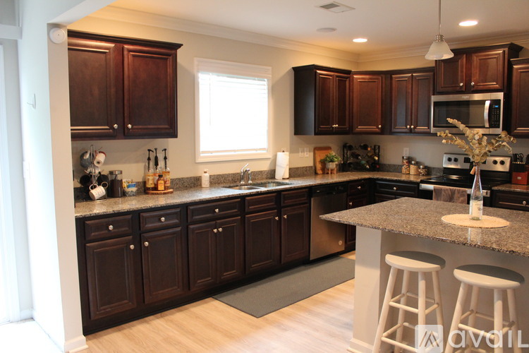 A kitchen with dark wood cabinets and a granite countertop.