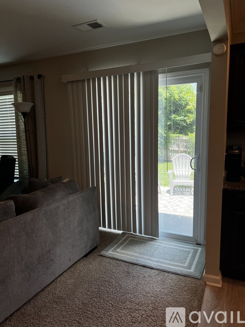 A living room with a grey couch and a sliding glass door.