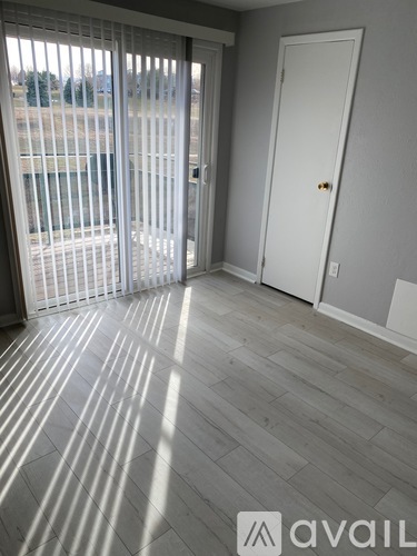 A room with a sliding glass door and a white door.