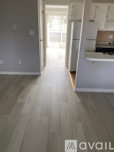 A kitchen with white cabinets and a white fridge.