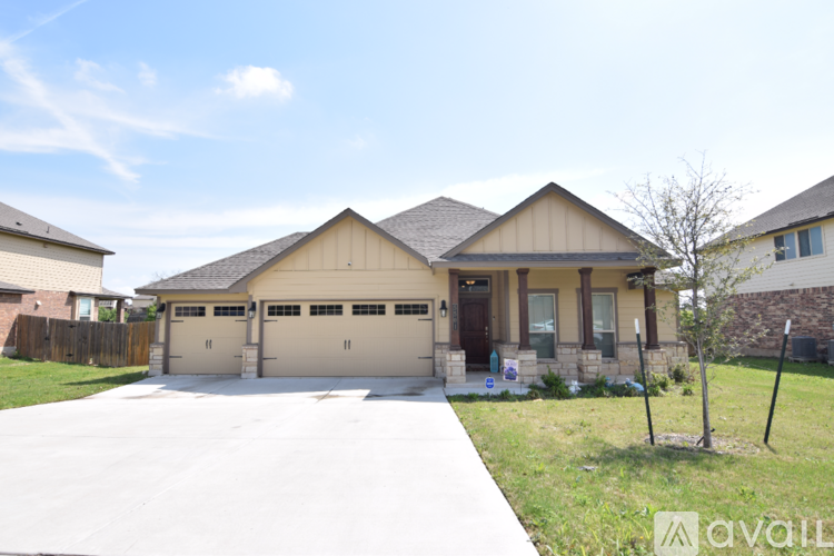 A house with a garage and a driveway in front of it.