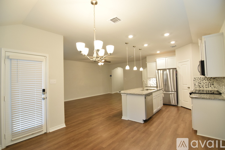A kitchen with white cabinets and a wooden floor.
