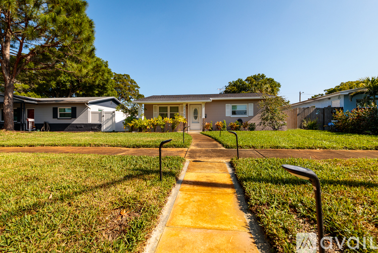 A yellow pathway leads to a house in a residential area.