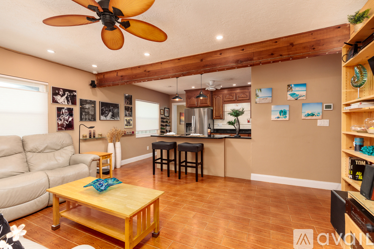 A living room with a wooden floor and a ceiling fan.