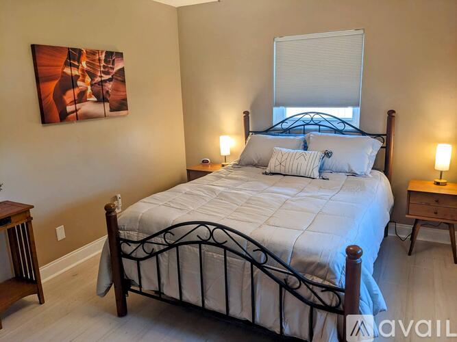 A bedroom with a large bed and a painting on the wall.