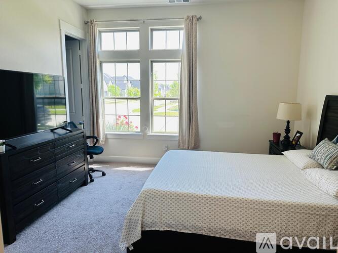 A bedroom with a large bed and a television.