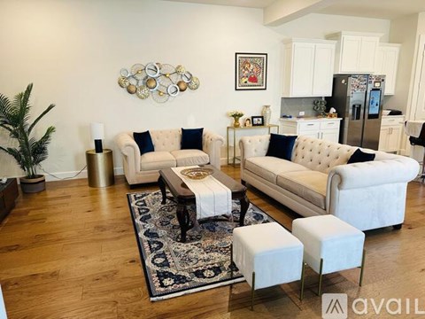 A living room with a white couch and a rug.