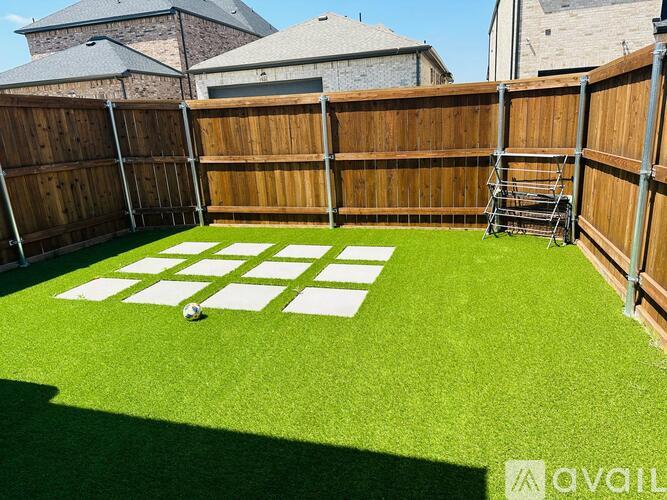 A backyard with a soccer ball and a checkerboard painted on the grass.