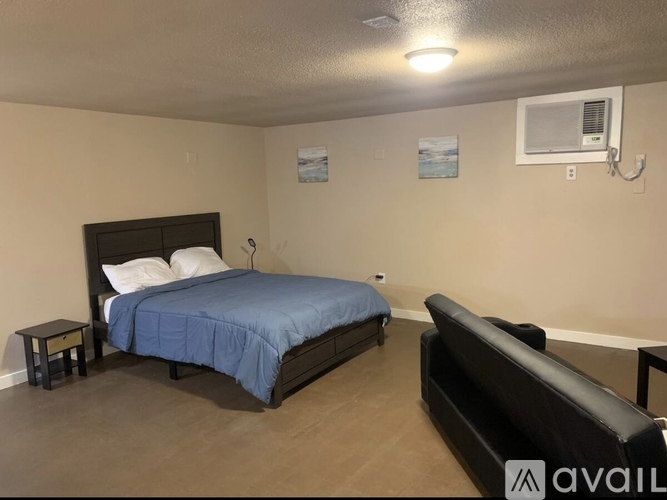 A bedroom with a bed, a couch, and a small table.