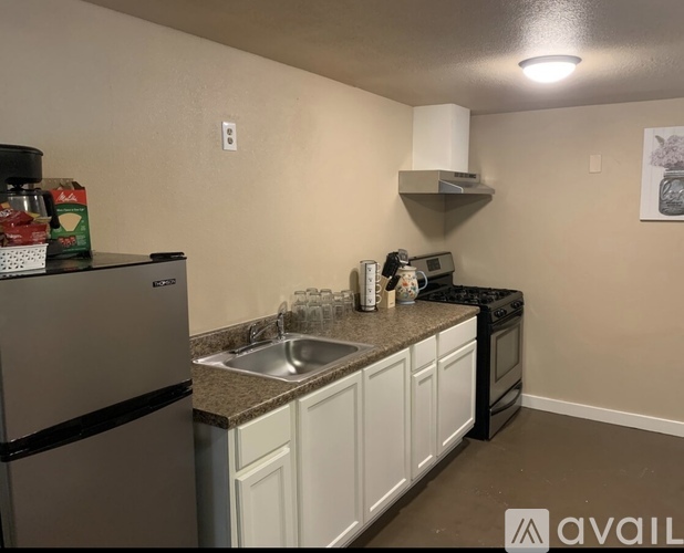 A kitchen with a stainless steel refrigerator and white cabinets.