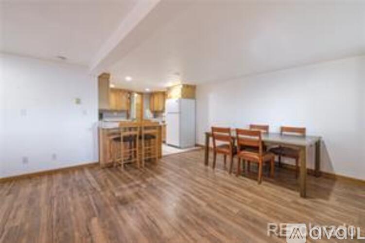 A room with a dining table and chairs.